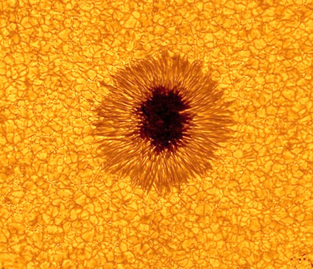 Ejemplo de mancha solar en la superficie del Sol. La umbra corresponde a la zona más oscura mientras que la penumbra en la región intermedia (un poco más clara). Fuente: New Solar Telescope, San Bernardino Mountains of California.